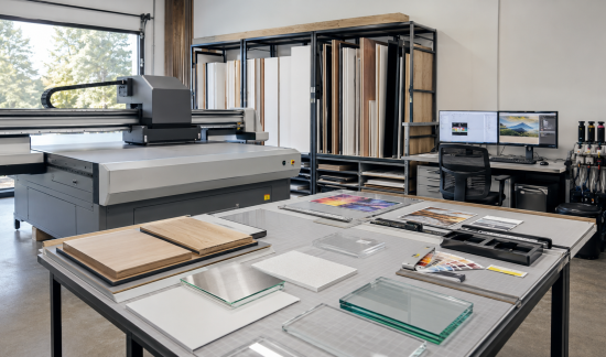 Professional technicians aligning an acrylic panel during the UV printing production process.