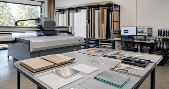 Professional technicians aligning an acrylic panel during the UV printing production process.